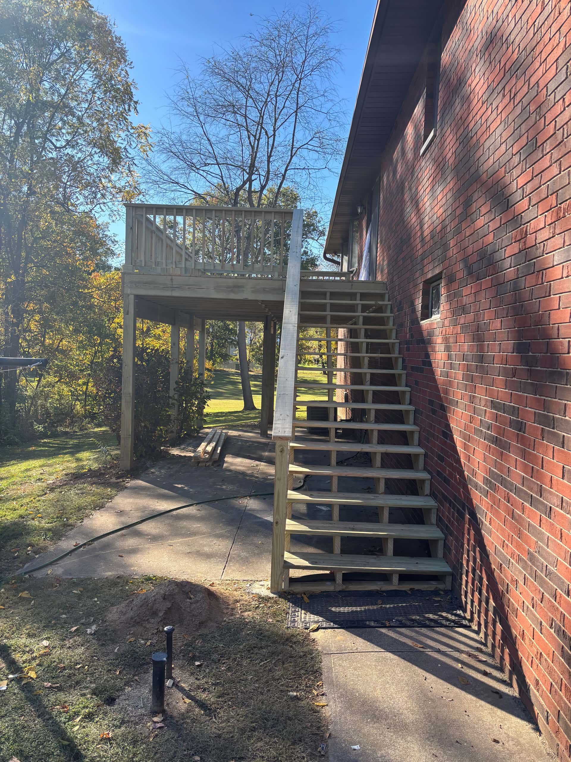 New pressure-treated deck addition with stairs on brick home in Lancaster, Ohio