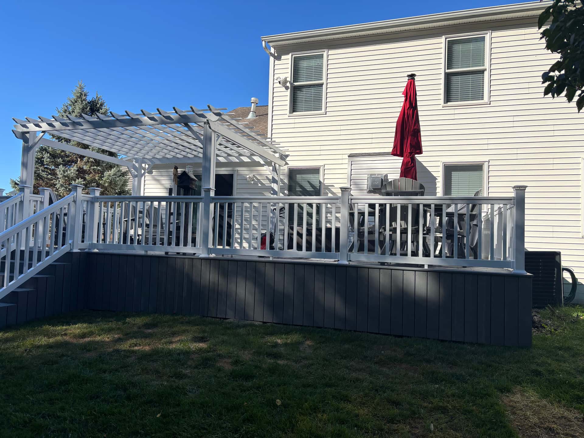 Composite deck with white pergola, skirting, and railing in Lancaster, Ohio