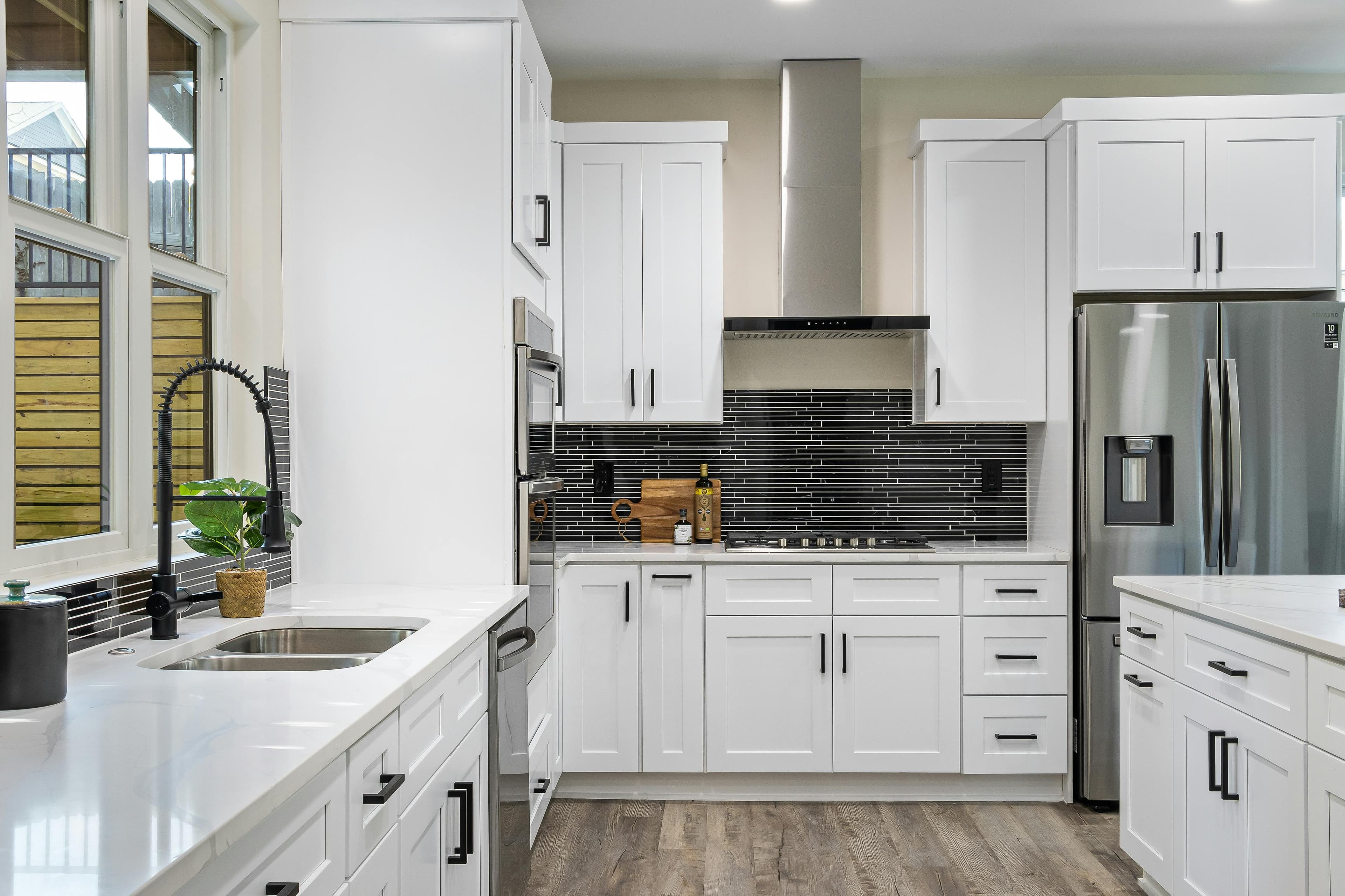 White shaker kitchen with black backsplash tile and matte black hardware in Lancaster, Ohio