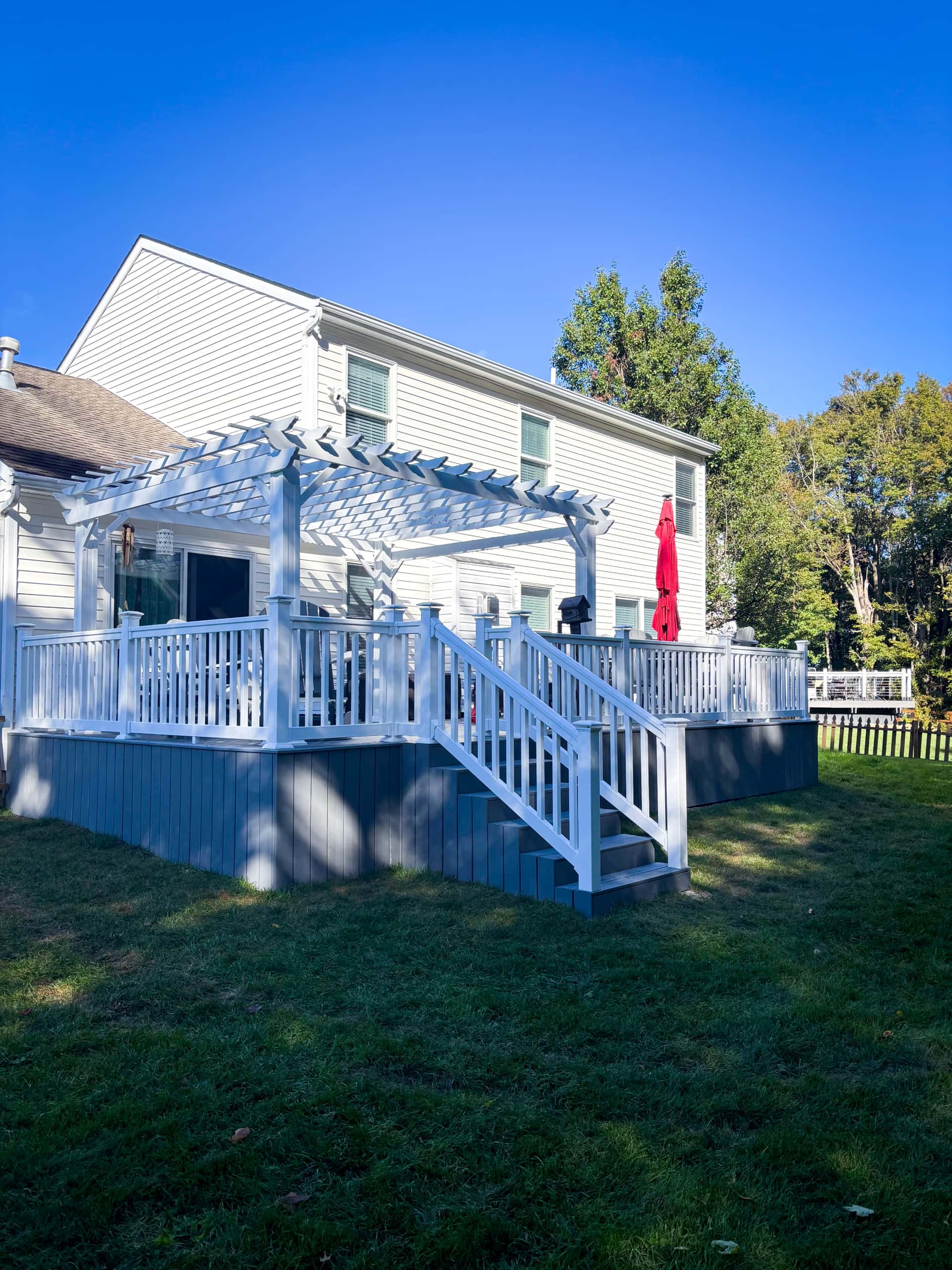 Elevated composite deck with white pergola and vinyl railing in Lancaster, Ohio
