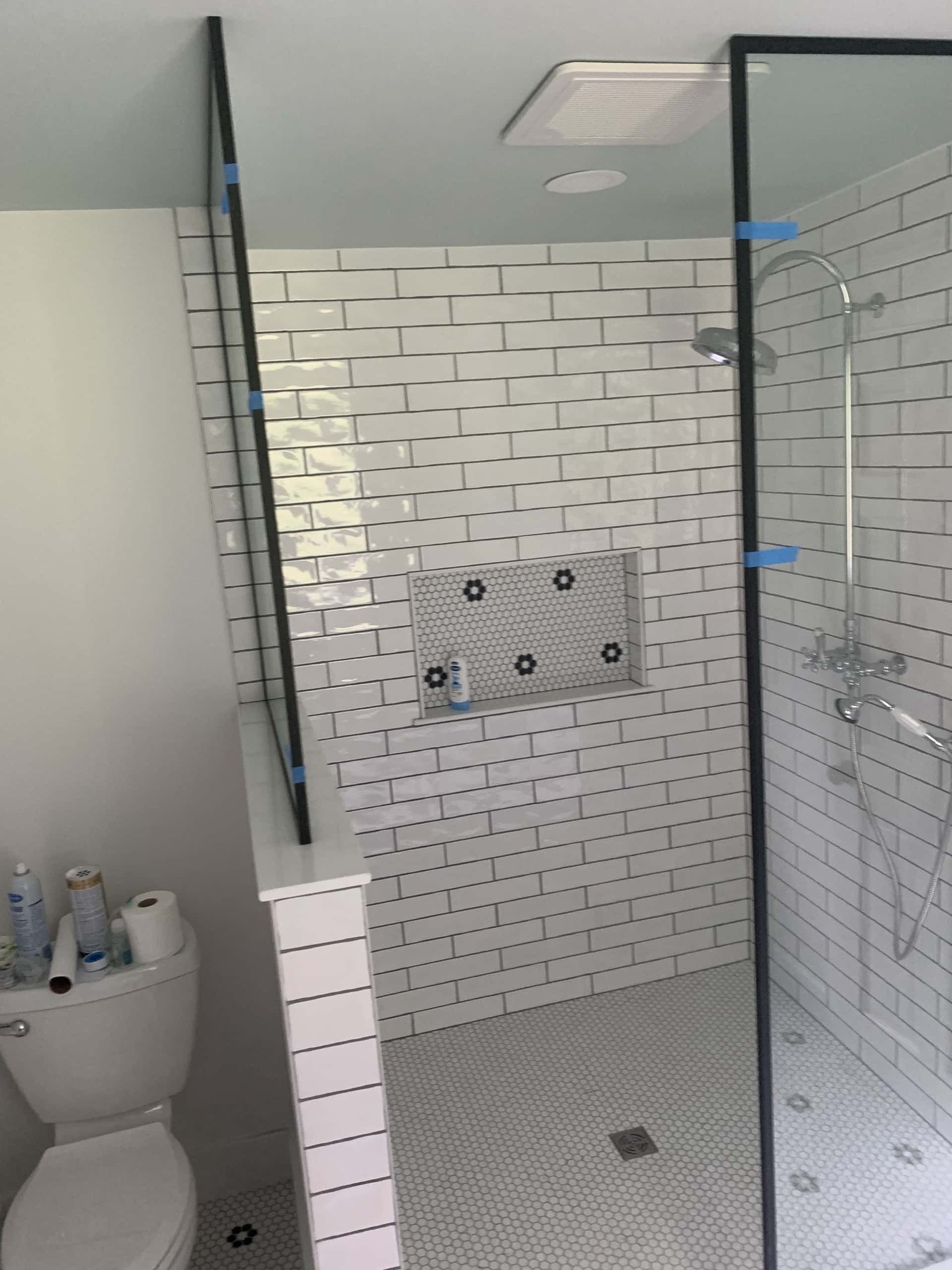 Walk-in shower with white subway tile and floral penny tile accents in Lancaster, Ohio