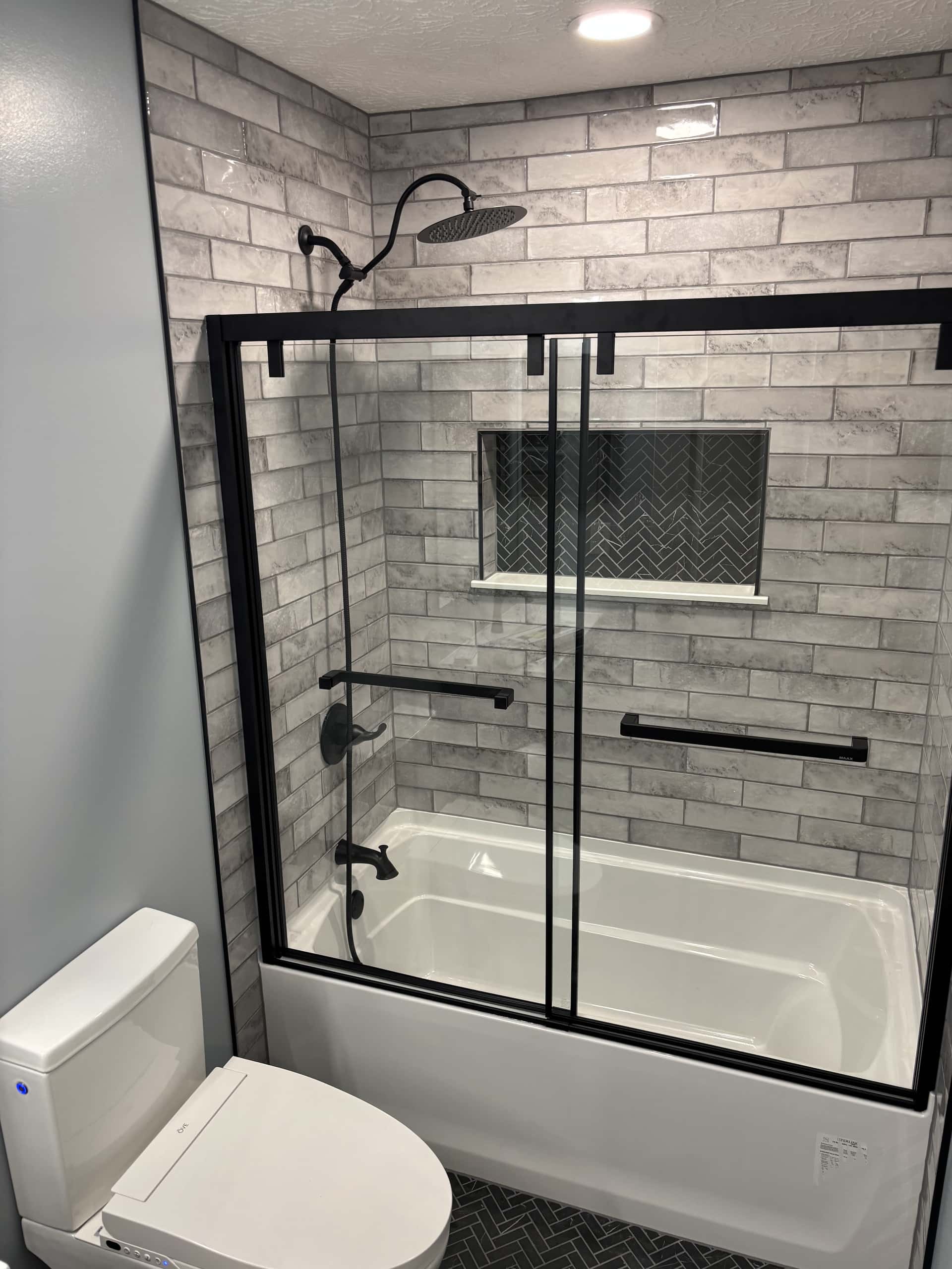 Tub surround with gray tile and herringbone niche in Lancaster, Ohio bathroom