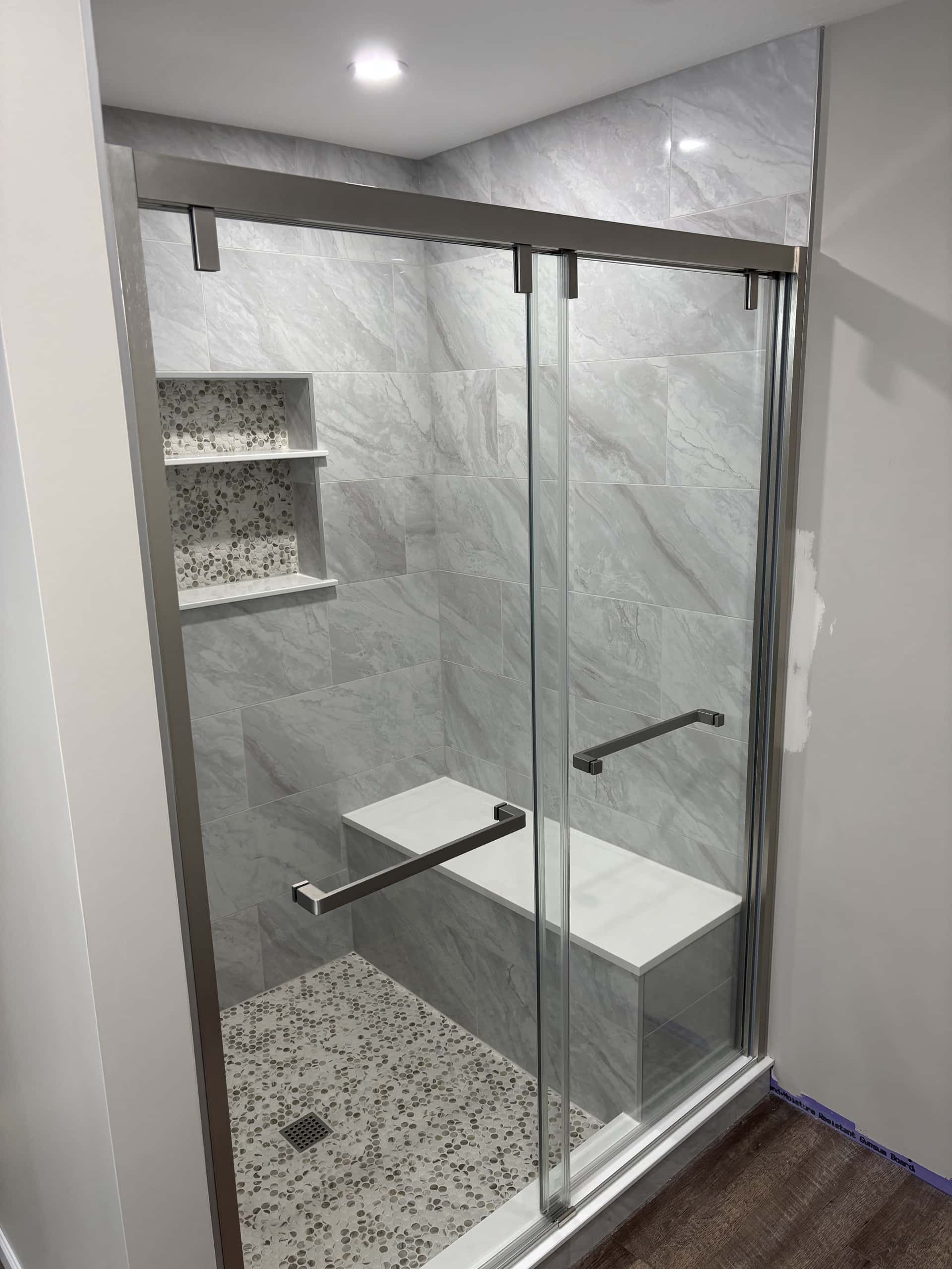 Walk-in shower with marble-look large format tile and built-in bench in Lancaster, Ohio