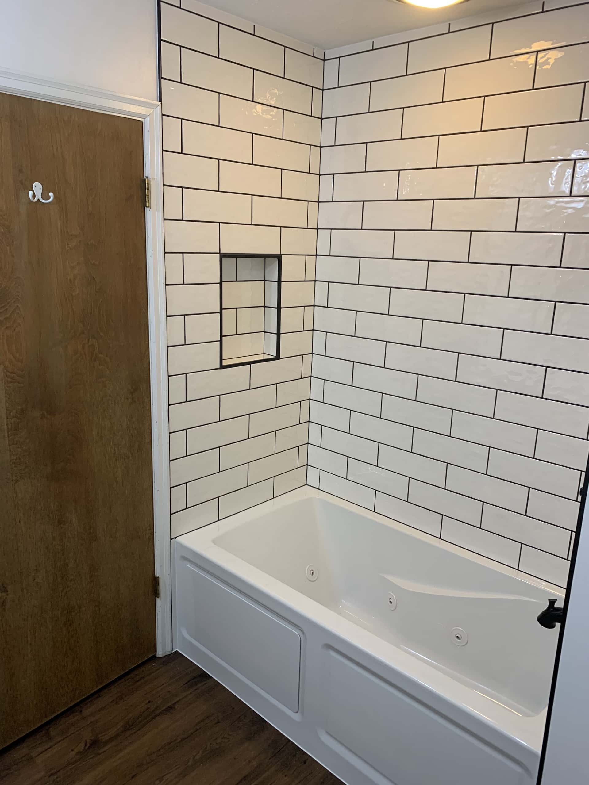 White subway tile tub surround with dark grout and jetted tub in Lancaster, Ohio