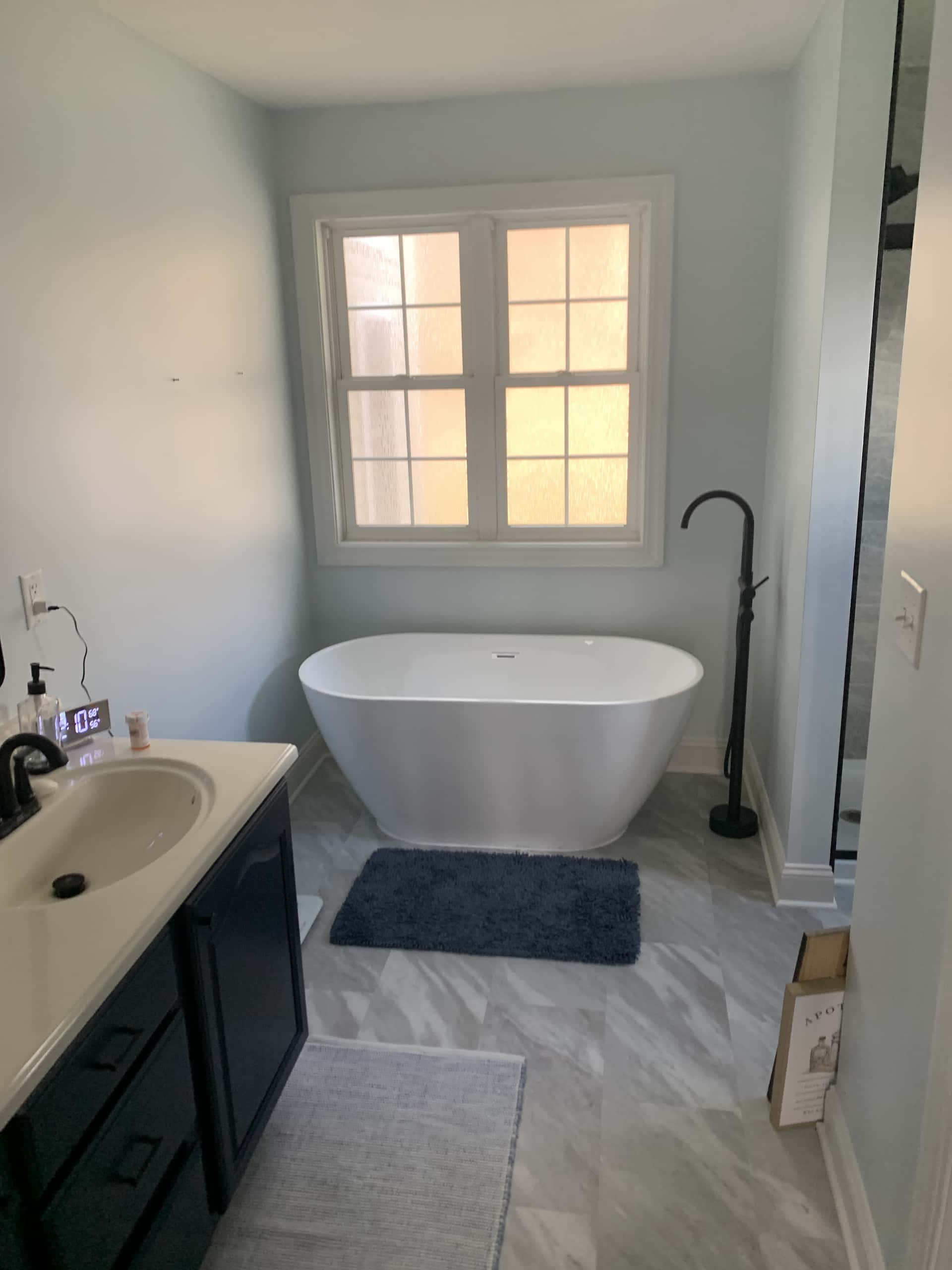 Master bathroom with freestanding soaking tub and dark navy vanity in Lancaster, Ohio
